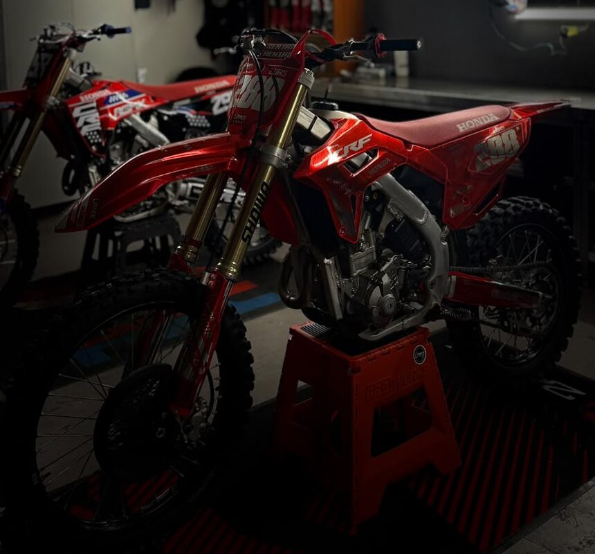 La Honda CRF 288 sur sa béquille rouge, fourche Showa, dans le garage.